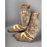 A pair of Inuit seal skin boots with straps across the foot, 41cm high. (2)