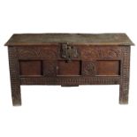 A 17th century boarded oak chest, the hinged lid revealing a lidded till, with an iron clasp and