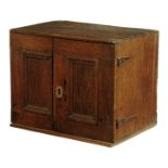 A William and Mary and later oak cabinet / spice cupboard, with a pair of hinged panelled doors