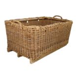 A large country house wicker log basket, with a pair of handles on sleigh type feet, 72cm high,