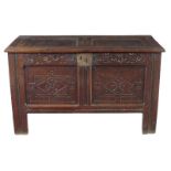 A late 17th century oak coffer, the twin panel hinged top revealing a lidded till, with a flower and