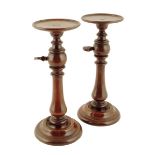 Treen. A pair of Victorian mahogany candlestands, each with an adjustable top on a baluster turned