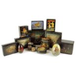 A collection of Russian lacquer items, with boxes and two eggs, painted with fairy tale scenes,