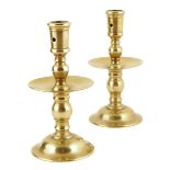 A pair of Dutch brass 'Heemskerk' style candlesticks, each with a pierced nozzle above a dished