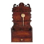 A George III oak spoon rack, the fret carved back above twelve spoon apertures, with one treen