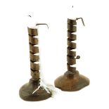 Two French iron spiral candlesticks, the stem of one stamped 'NA & LM', each on a fruitwood base,