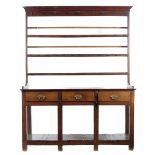 A George III oak potboard dresser, the plate rack with three shelves and with iron hooks, the base