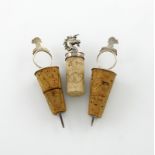 A small collection of three silver bottle stoppers, comprising a Victorian armorial stopper, by E. C