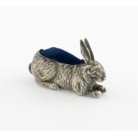 An Edwardian silver rabbit pin cushion, by H. Matthews, Birmingham 1909, modelled in a recumbent