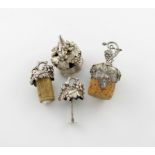 A small collection of four Victorian silver bottle stoppers, modelled as bunches of grapes,