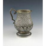 An Indian silver mug, unmarked circa 1900, baluster form, chased foliate scroll decoration above