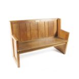 A Barnsley Workshops oak pew bench, solid plank back and panelled ends, with applied memorial