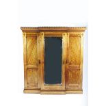 A large Gothic Revival oak wardrobe, two panelled doors flanking central mirrored door, internally
