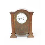 An oak mantle clock probably retailed by Liberty & Co, the rounded rectangular body supported on