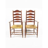 A pair of Clissett ash armchairs, ladderback, with rush seats, 114cm. high, (2).