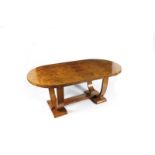 An English Art Deco satinwood dining table and six chairs, the rounded rectangular table on U