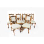 A set of six Gothic Revival walnut dining chairs, with carved foliate panels to back, padded seats,