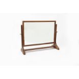 A Gordon Russell oak dressing table mirror, the rectangular adjustable mirror on simple carved