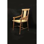 An oak armchair in the manner of John Pollard Seddon, flaring carved legs with pegged stretcher,