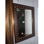 A small wall mirror with rectangular bevelled edge plate within an antique hardwood rectangular