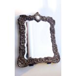 An Edwardian silver easel mirror, Charles Henry Dumenil, London, 1905, the shaped rectangular border