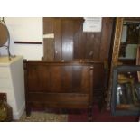 A continental oak single bedstead with shaped outline and rolled top rail