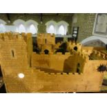 A vintage plywood model of a Medieval castle with faux brickwork paper lined and further painted