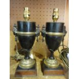 A pair of urn shaped desk lamps, principally in polished slate with ormolu type mounts, raised on