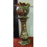 A late 19th century green ground jardinière and stand with painted and gilded pink poppy decoration