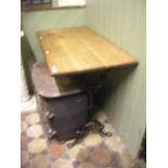 A pub table with rectangular oak top raised on shaped cast iron end supports