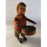 A small late 19th/early 20th century clockwork model of a drum playing clown portrayed with