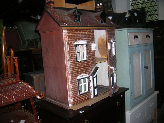 A vintage childs dolls house timber framed with hand painted simulated red brickwork façade