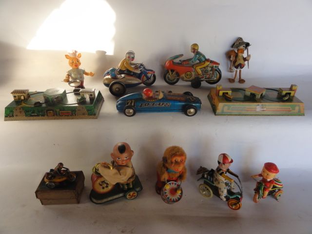 A selection of vintage toys to include a pair of clockwork printed tin models of lapping trains