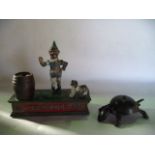 A vintage novelty money box with a spring loaded dog, to accommodate coins within its mouth and