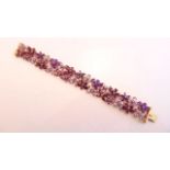 A gem-set bracelet, QVC, composed of flower head motifs, each set with a purple gemstone, centred