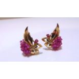 A pair of earrings, each of floral form, highlighted with a cluster of untested cabochon rubies,