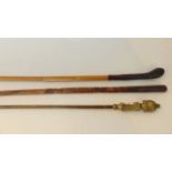 A heavy iron tipped brass fireside poker together with a carved eastern walking cane with detail