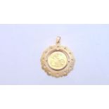 A half sovereign pendant, 1982, the 9ct gold border with engine-turned decoration, 7g