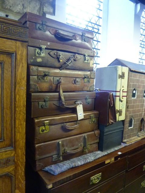 Six vintage suitcases, mainly leather examples, a small tin trunk, a briefcase and a small aluminium