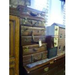 Six vintage suitcases, mainly leather examples, a small tin trunk, a briefcase and a small aluminium