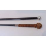 An ebonised walking cane with applied white metal knop handle bearing Chinese character marks