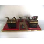 A board mounted assembly of two steam engine units complete with further pistons, driving wheels,