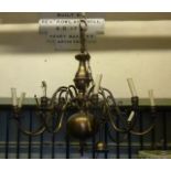 A large anodised brass hanging ceiling light with ten scrolling branches surrounding a bulbous and