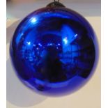 A blue glass Witches Ball with iridescent finish