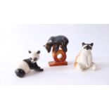 A collection of three Russian models including a circus bear standing on a hoop, a seated racoon and