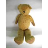 A large antique teddybear with stitched feet