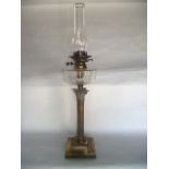 A good quality Victorian brass oil burning lamp raised on a Corinthian column stand, set before a