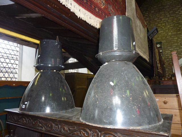 A pair of industrial enamelled tin hanging ceiling lights with domed shades