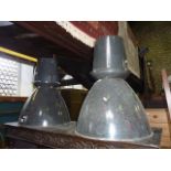 A pair of industrial enamelled tin hanging ceiling lights with domed shades
