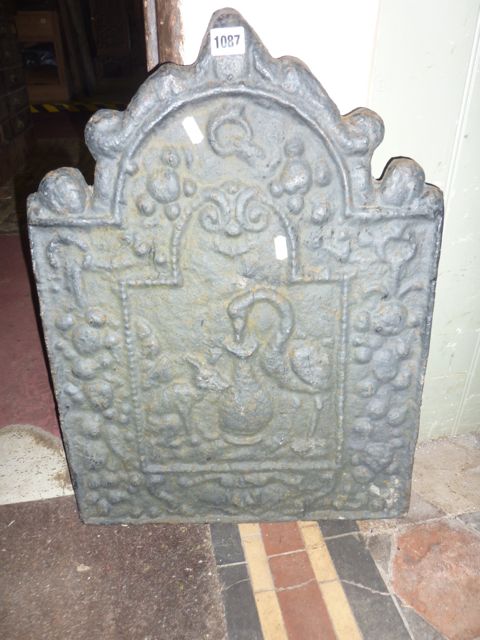 A small vintage cast iron fire back of stepped arched form with raised relief stork and trailing